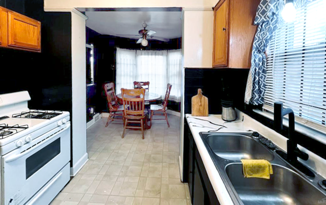 kitchen with sink, gas range gas stove, and ceiling fan