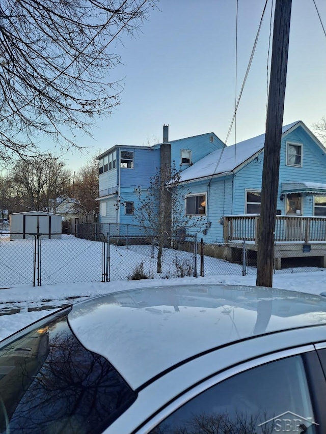 exterior space featuring a deck, a shed, an outbuilding, and fence