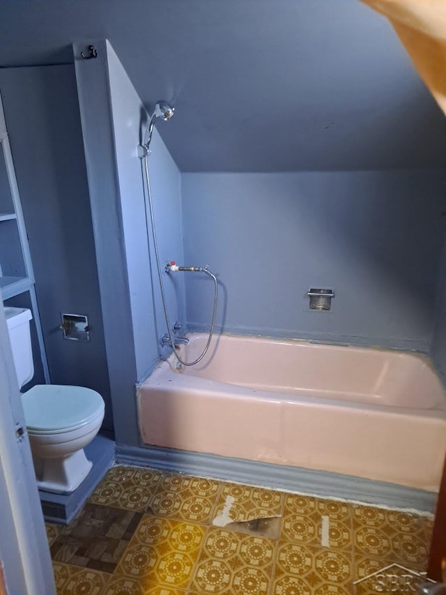 bathroom with a tub to relax in, toilet, and tile patterned floors