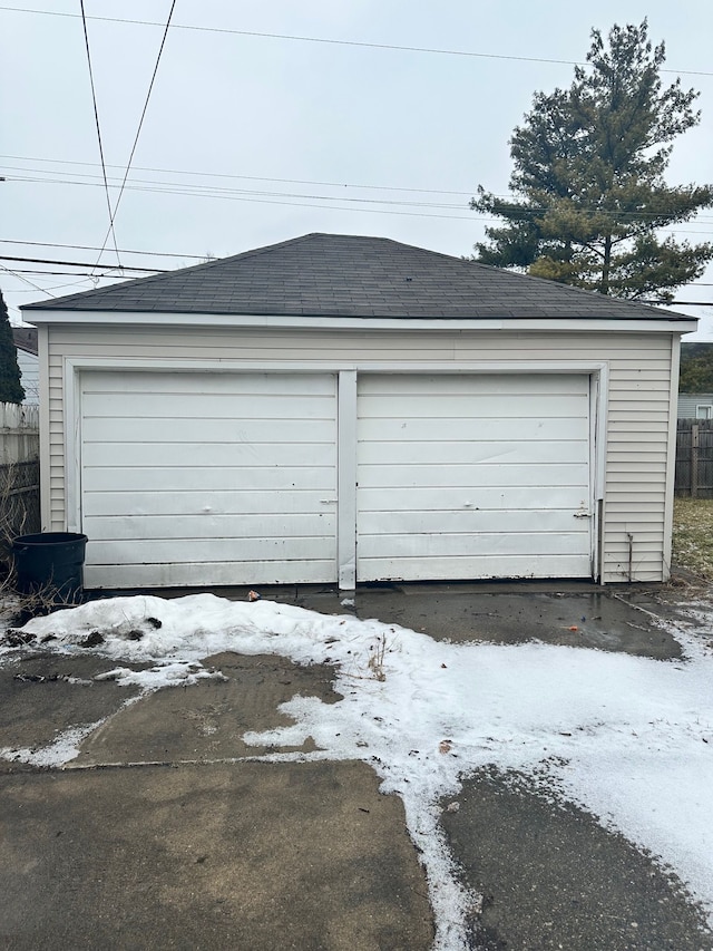 detached garage featuring fence