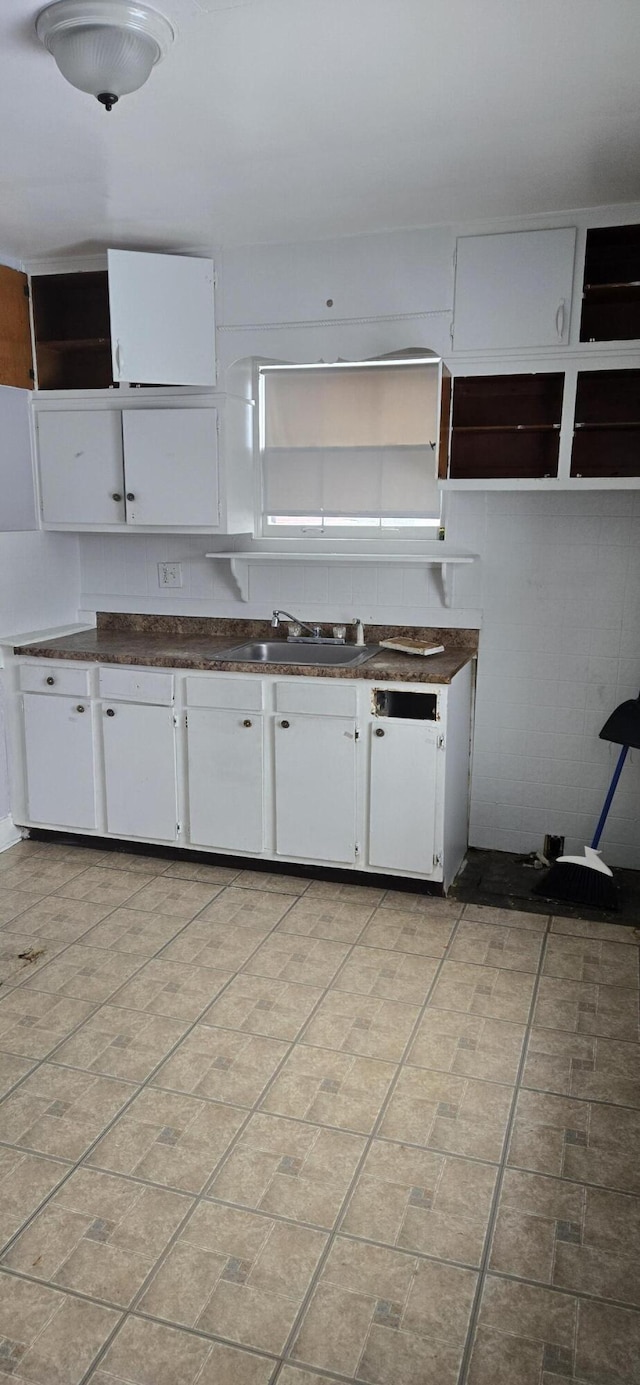 kitchen with dishwashing machine, sink, and white cabinets