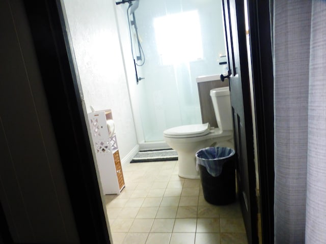 bathroom featuring curtained shower, tile patterned floors, and toilet