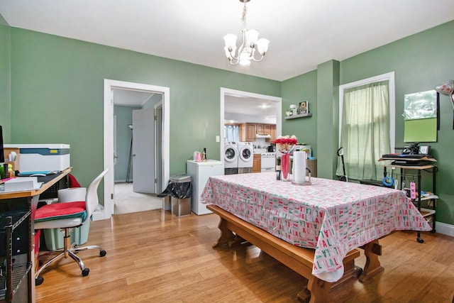 bedroom featuring separate washer and dryer, a chandelier, and light hardwood / wood-style flooring