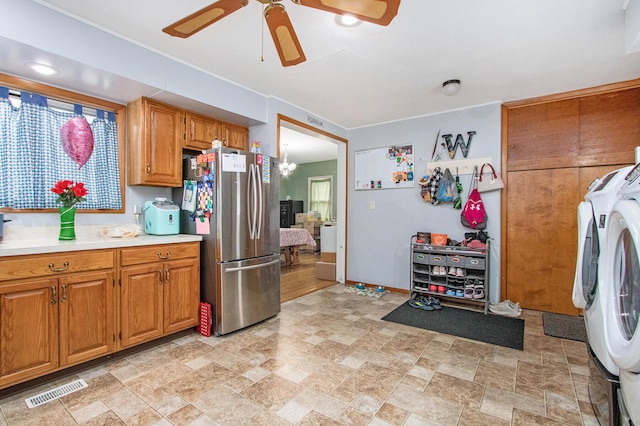 kitchen featuring ceiling fan, washing machine and clothes dryer, and stainless steel refrigerator