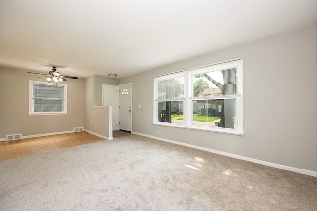 carpeted spare room featuring ceiling fan