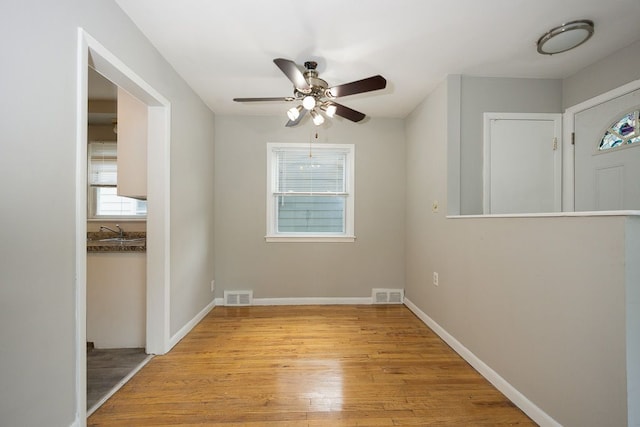 unfurnished room featuring sink, light hardwood / wood-style flooring, and ceiling fan