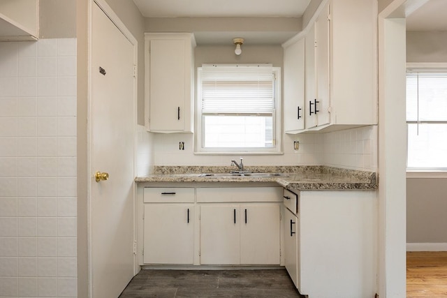 kitchen featuring white cabinetry, sink, and a healthy amount of sunlight