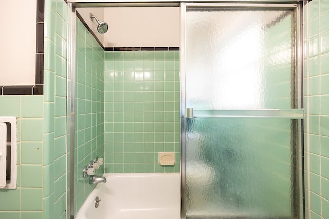 bathroom featuring combined bath / shower with glass door