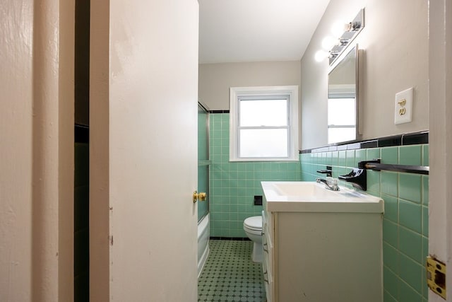 full bathroom with vanity, bathing tub / shower combination, tile walls, and toilet