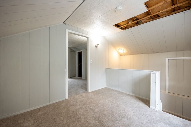 bonus room with vaulted ceiling and light carpet