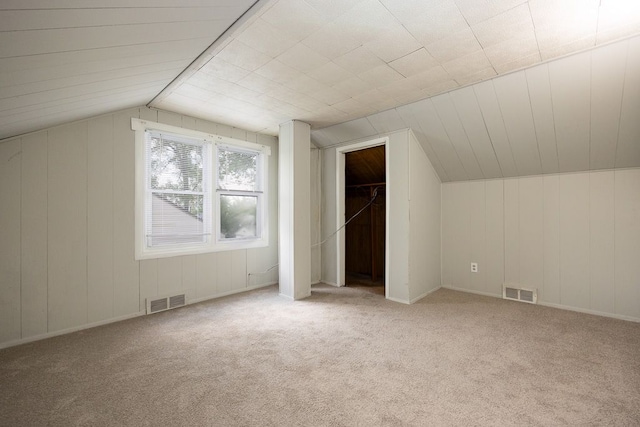 bonus room with light carpet and vaulted ceiling