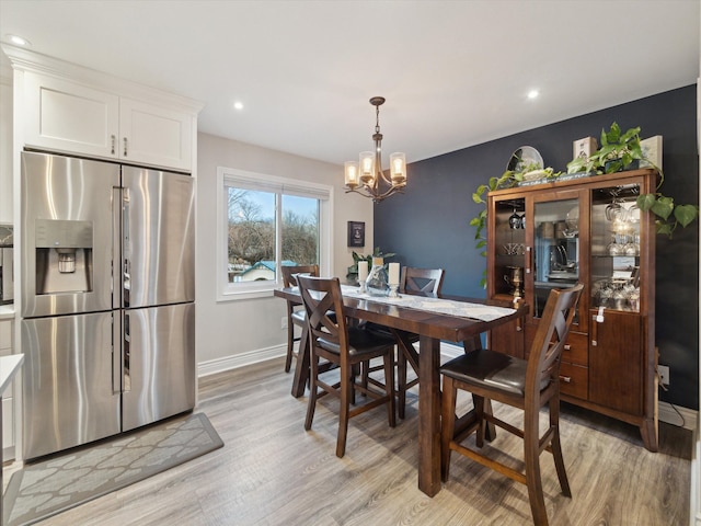 dining area featuring an inviting chandelier and light wood-type flooring