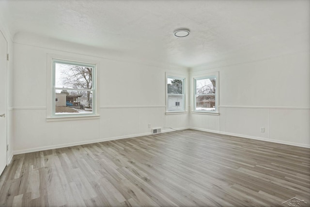 spare room featuring wood-type flooring and a textured ceiling