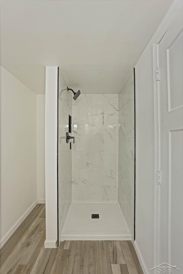 bathroom featuring hardwood / wood-style floors and tiled shower