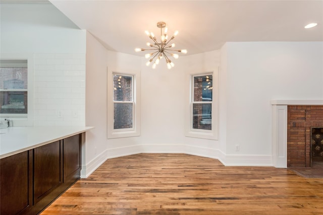 unfurnished dining area featuring a notable chandelier and light hardwood / wood-style flooring