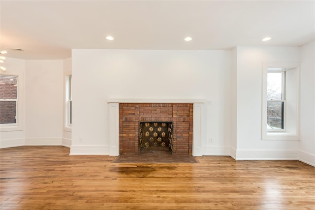 unfurnished living room with a fireplace and light wood-type flooring