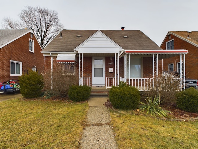 bungalow-style home with a front yard and covered porch