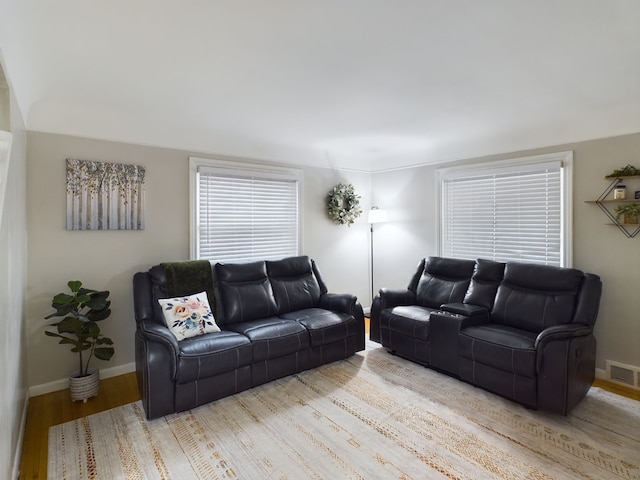 living area with visible vents, baseboards, and light wood-style flooring