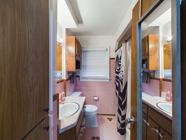 bathroom with vanity, tile walls, toilet, and a shower with curtain