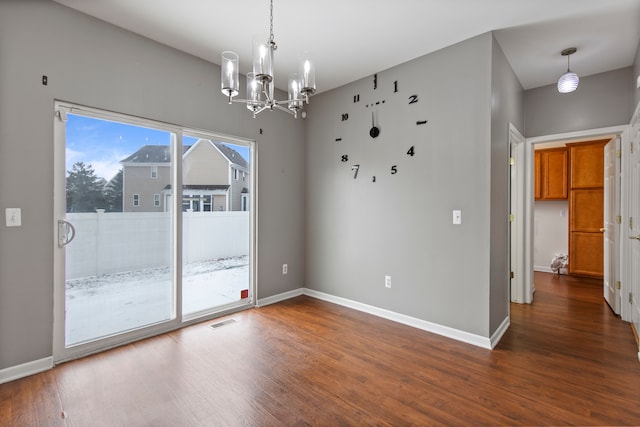 unfurnished room featuring dark hardwood / wood-style floors and a notable chandelier