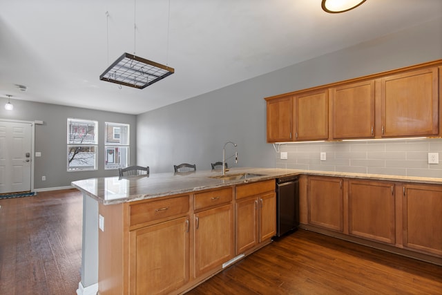 kitchen featuring tasteful backsplash, black dishwasher, sink, and kitchen peninsula