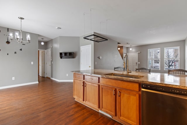 kitchen featuring sink, dark wood-type flooring, dishwasher, hanging light fixtures, and light stone counters