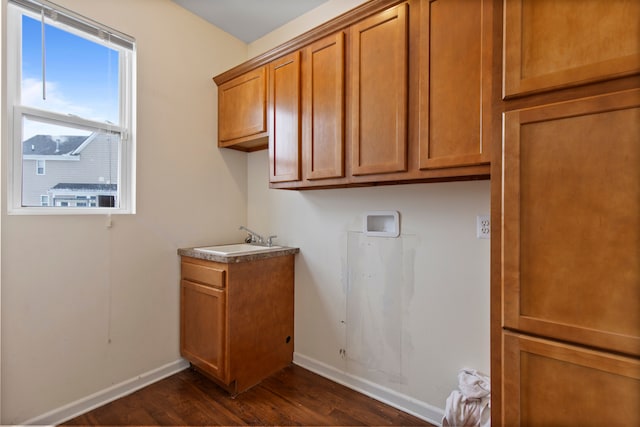 clothes washing area with cabinets, sink, and dark wood-type flooring