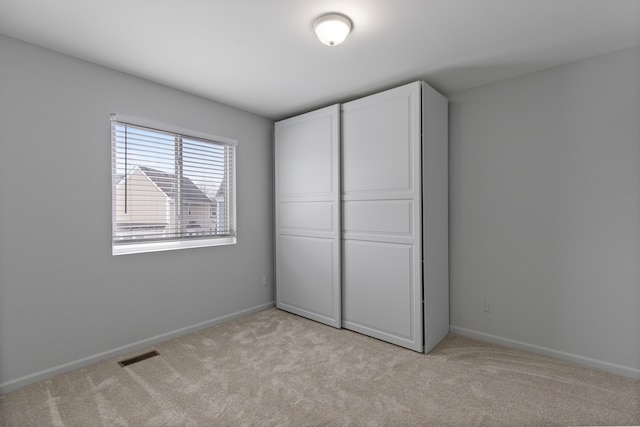 unfurnished bedroom with light colored carpet