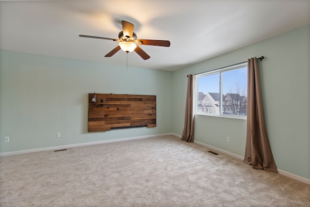 empty room featuring ceiling fan and light carpet