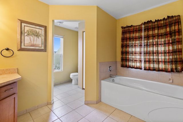 bathroom featuring vanity, a bathing tub, tile patterned floors, and toilet