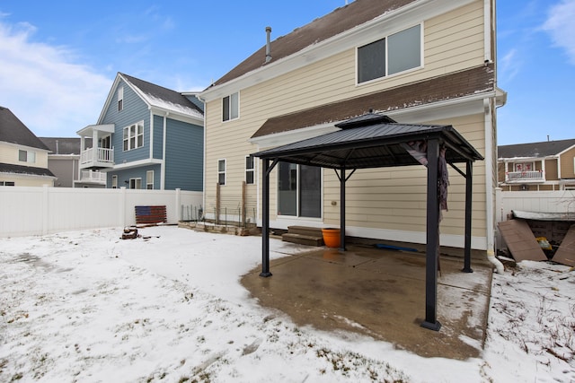 snow covered rear of property with a gazebo