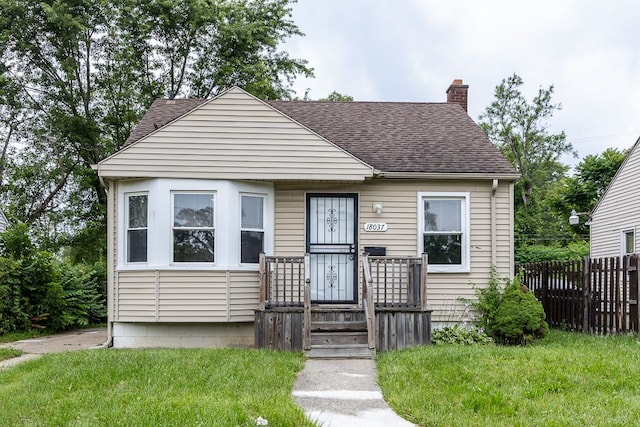 bungalow-style home with a front yard