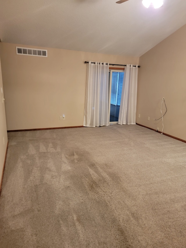 carpeted empty room with vaulted ceiling and ceiling fan