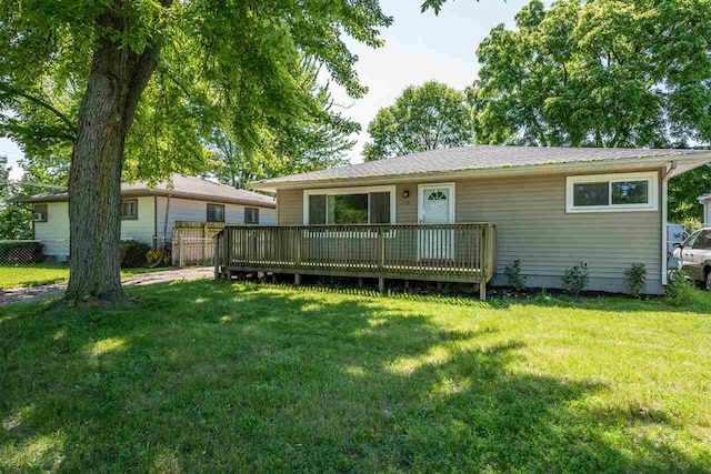 rear view of house featuring a deck and a lawn