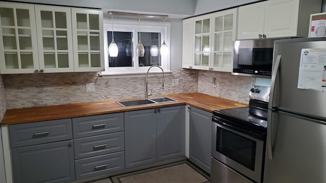 kitchen featuring sink, gray cabinetry, wooden counters, stainless steel appliances, and white cabinets