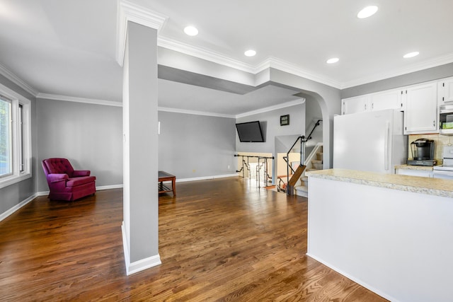 kitchen featuring white cabinetry, ornamental molding, dark hardwood / wood-style floors, and white fridge