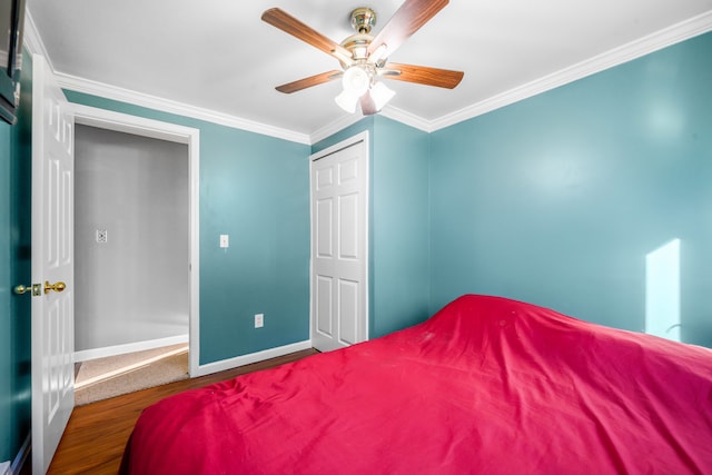 bedroom featuring crown molding, wood-type flooring, a closet, and ceiling fan