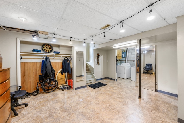 basement featuring a paneled ceiling, independent washer and dryer, and track lighting