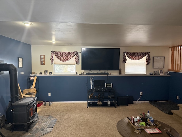 carpeted living room with a wood stove