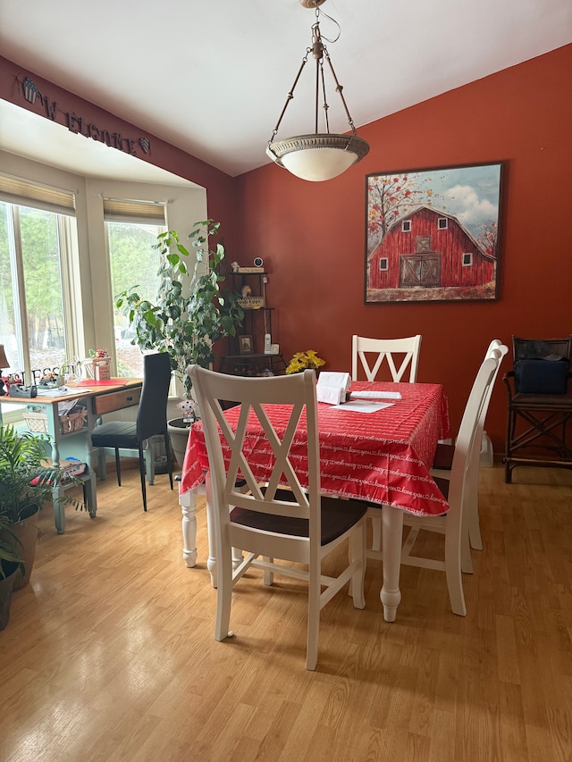 dining area with lofted ceiling and hardwood / wood-style floors