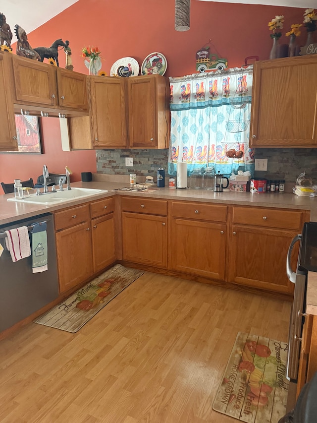 kitchen featuring sink, range, vaulted ceiling, stainless steel dishwasher, and light hardwood / wood-style floors