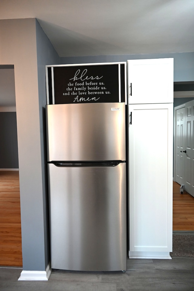 kitchen featuring white cabinetry, dark hardwood / wood-style floors, and stainless steel fridge