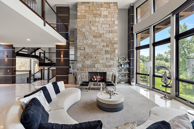 living room featuring a towering ceiling and a stone fireplace