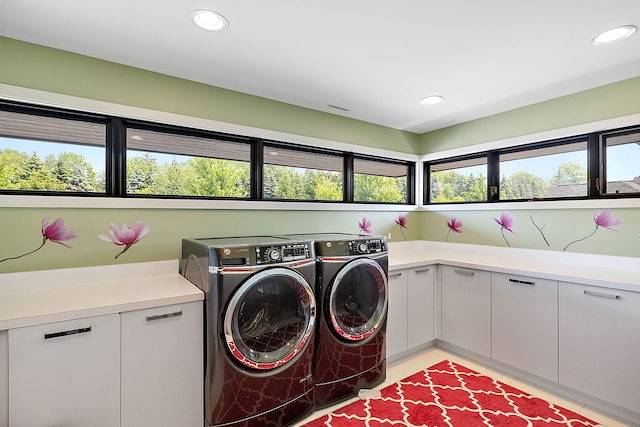 laundry area with light tile patterned flooring, cabinets, and washing machine and dryer