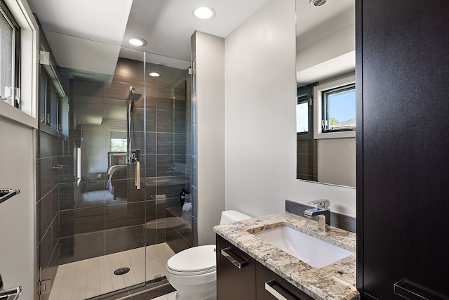 bathroom featuring walk in shower, vanity, and toilet