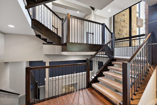 stairs with a wall of windows and hardwood / wood-style floors