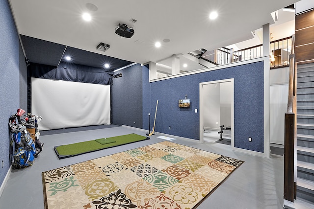 interior space featuring golf simulator and concrete floors