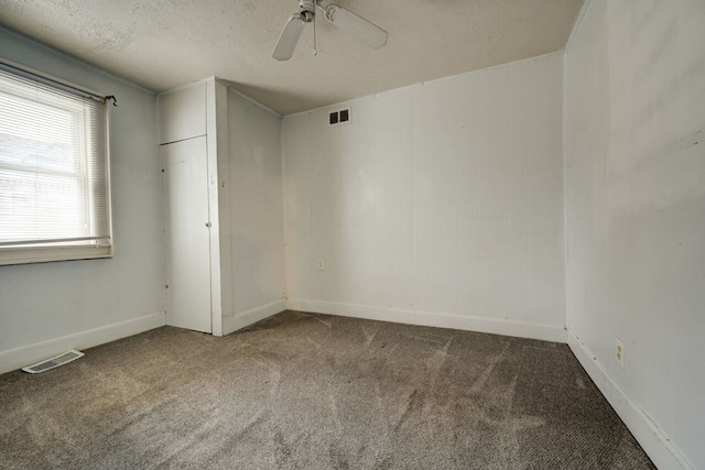 unfurnished room featuring ceiling fan, carpet, and a textured ceiling