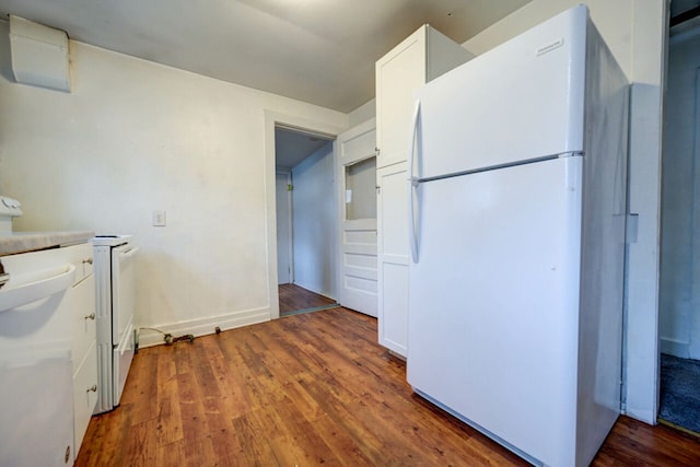 kitchen featuring white cabinetry, dark hardwood / wood-style flooring, and white fridge