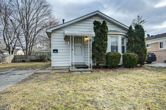 bungalow-style home with a front lawn